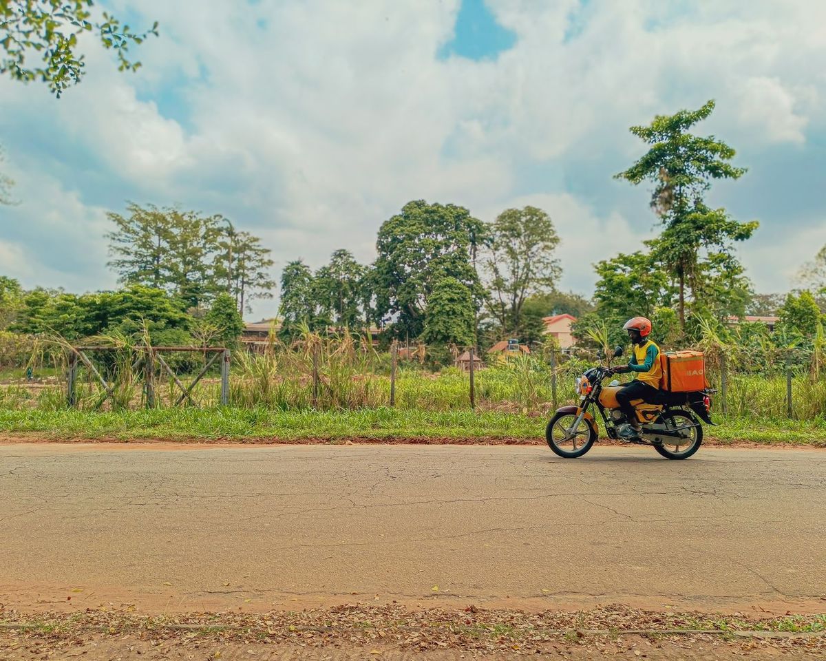 A delivery rider carrying a box on a motorcycle on a road in Lagos